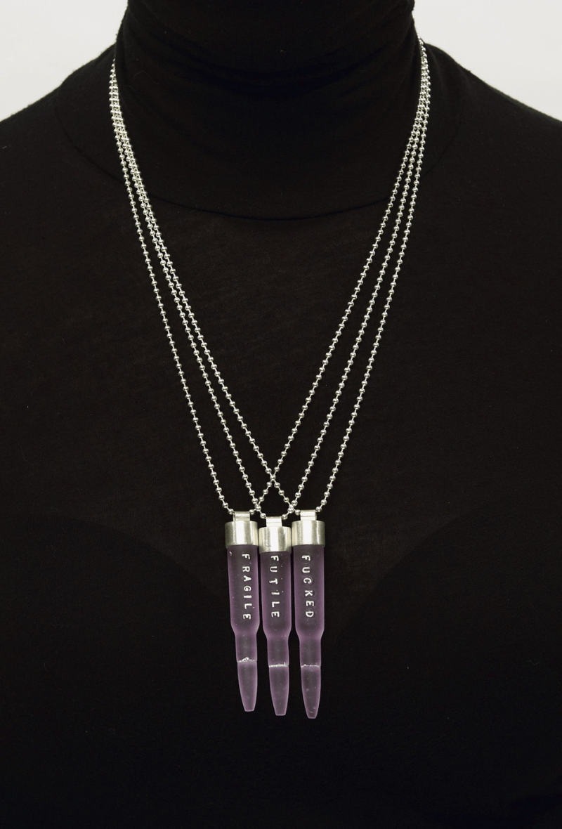 Three pink cast glass bullet necklaces.
